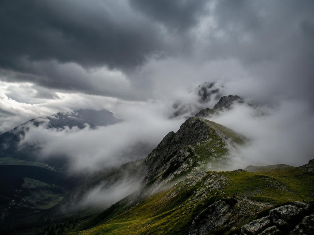 Wolken und Nebel ziehen über einen Bergkamm